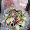 Bouquet of pink and white flowers wrapped in white lace paper