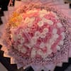 Large bouquet of pink and white roses with a pink ribbon and decorative wrap