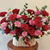 A lush cascade of red roses and soft pink carnations fills a