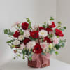 A lush, low wicker basket brimming with red and pale pink roses