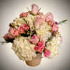 Pink roses and white hydrangeas arranged in a ribbed vase
