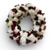 Circular floral wreath of white and deep red flowers
