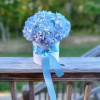 Blue hydrangea arrangement in a white box with a blue ribbon