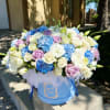 Blue, white, and lavender bouquet in a round blue box