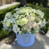 White and pale green flower arrangement in a blue hatbox