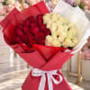 Bouquet of red and cream roses wrapped in red and white paper