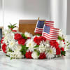 Red and white floral arrangement with two small American flags