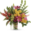 Mixed bouquet of pink lilies, yellow roses, and orchids in a glass vase