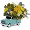 Yellow roses and chrysanthemums arranged in a turquoise truck planter