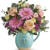Pink gerbera daisies and roses in a turquoise mug vase