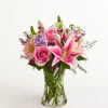 Pink roses and lilies in a clear glass vase