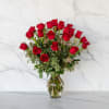 Red roses arranged in a clear glass vase