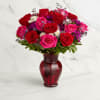 Bouquet of red and pink roses in a red glass vase
