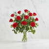 Red roses arranged in a clear glass vase