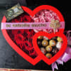 Heart-shaped box of red and pink roses with chocolates and a ribbon