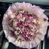 Pink rose bouquet with small white filler flowers and a satin bow