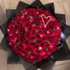 Large bouquet of red roses wrapped in black paper with a candy cane heart