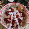 Bouquet of red and blush roses with a gingerbread plush and holiday ornaments