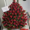 Large arrangement of red roses with a box of chocolates