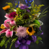 A tall, garden-style mixed bouquet that greets the eye with cheerful sunflowers