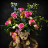 Bright pink roses punctuate this cheerful flower arrangement, paired with airy blue