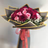 Bouquet of red and pink roses wrapped in black paper with a pink ribbon
