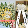 A bright, ceremonial standing sympathy spray designed to honor a loved one