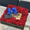 Box of red roses with a blue bow and chocolates