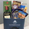 Father's Day gift basket with whiskey, snacks, and a blue box