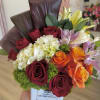 Bouquet of red and orange roses with white hydrangea in a white vase