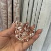 Hand holding a small rose-gold jeweled crown