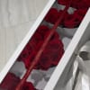Red roses arranged in a white gift box with a ribbon