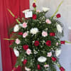 Standing floral spray with red roses, white chrysanthemums, and pink carnations