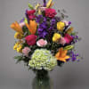 Vivid hot-pink roses and fiery orange lilies create an immediate burst of