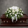 A serene, traditional white casket spray that conveys deep sympathy with quiet