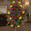A tall, triangular standing spray that brings warm color and comforting presence