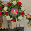 Floral wreath with red roses and white chrysanthemums around a sports logo