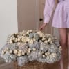 Large basket arrangement of cream roses and pale blue hydrangeas