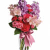 Pink and purple mixed bouquet in a clear glass vase with a satin ribbon