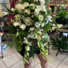 Large white bouquet with roses and orchids, held by a person