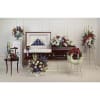 Casket surrounded by red, white, and blue funeral flower arrangements