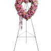 Heart-shaped pink floral wreath on a standing easel with ribbon