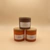 Three labeled candles with wooden lids on a neutral background