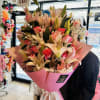 Large pink bouquet of lilies and roses wrapped in pink paper