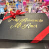 Black gift box with red ribbon and gold anniversary text