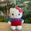 Hello Kitty plush toy in red overalls with a polka-dot bow