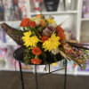 Bouquet of orange and yellow flowers with decorative gourds