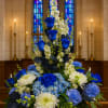 Blue roses and white flowers arranged in a tall church display