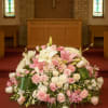 Large pink and white funeral spray in a church sanctuary