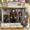 Harry Potter toy set with figures of Hagrid, Hermione, and a dog in a box